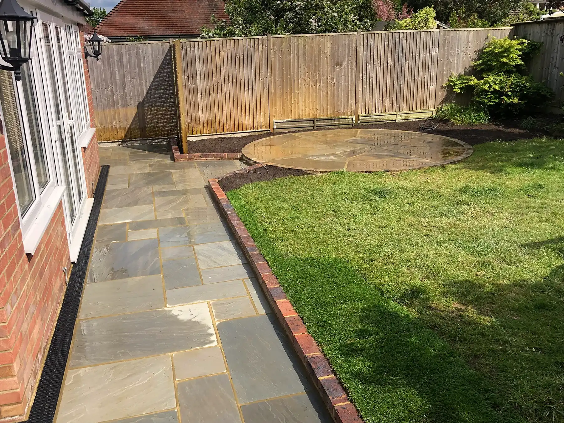 a back yard with a stone path leading to the back of the house