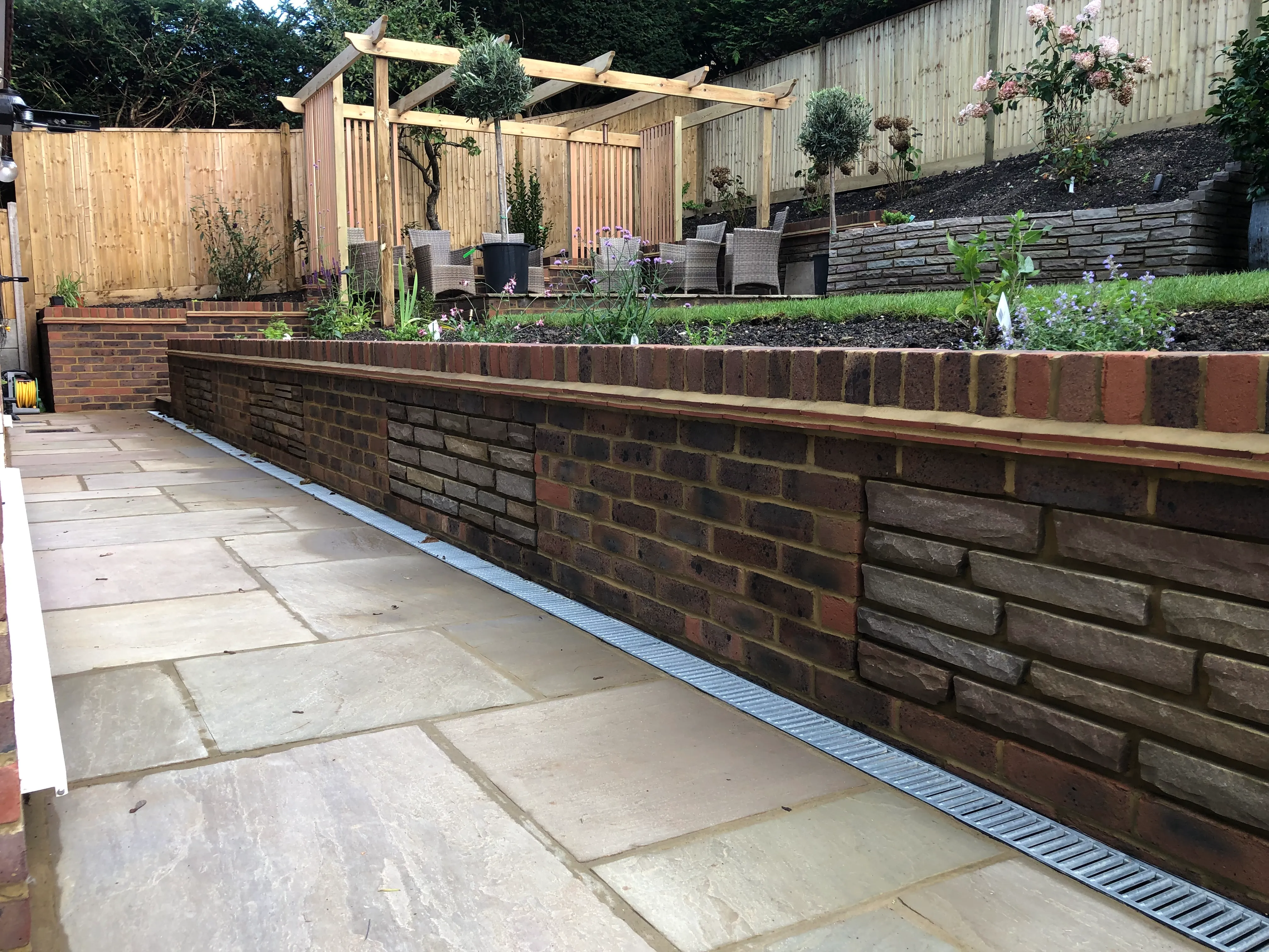 A brick retaining wall in a back yard.